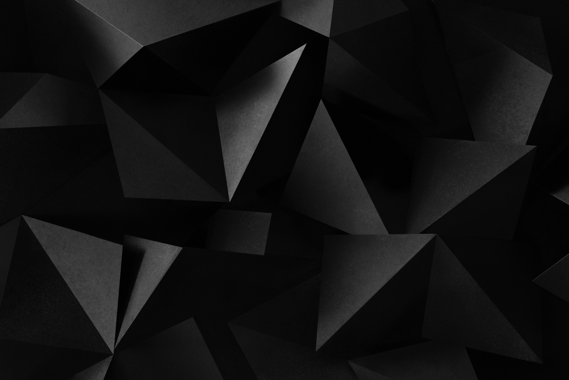 Close-up of triangular shapes of paper, dark background